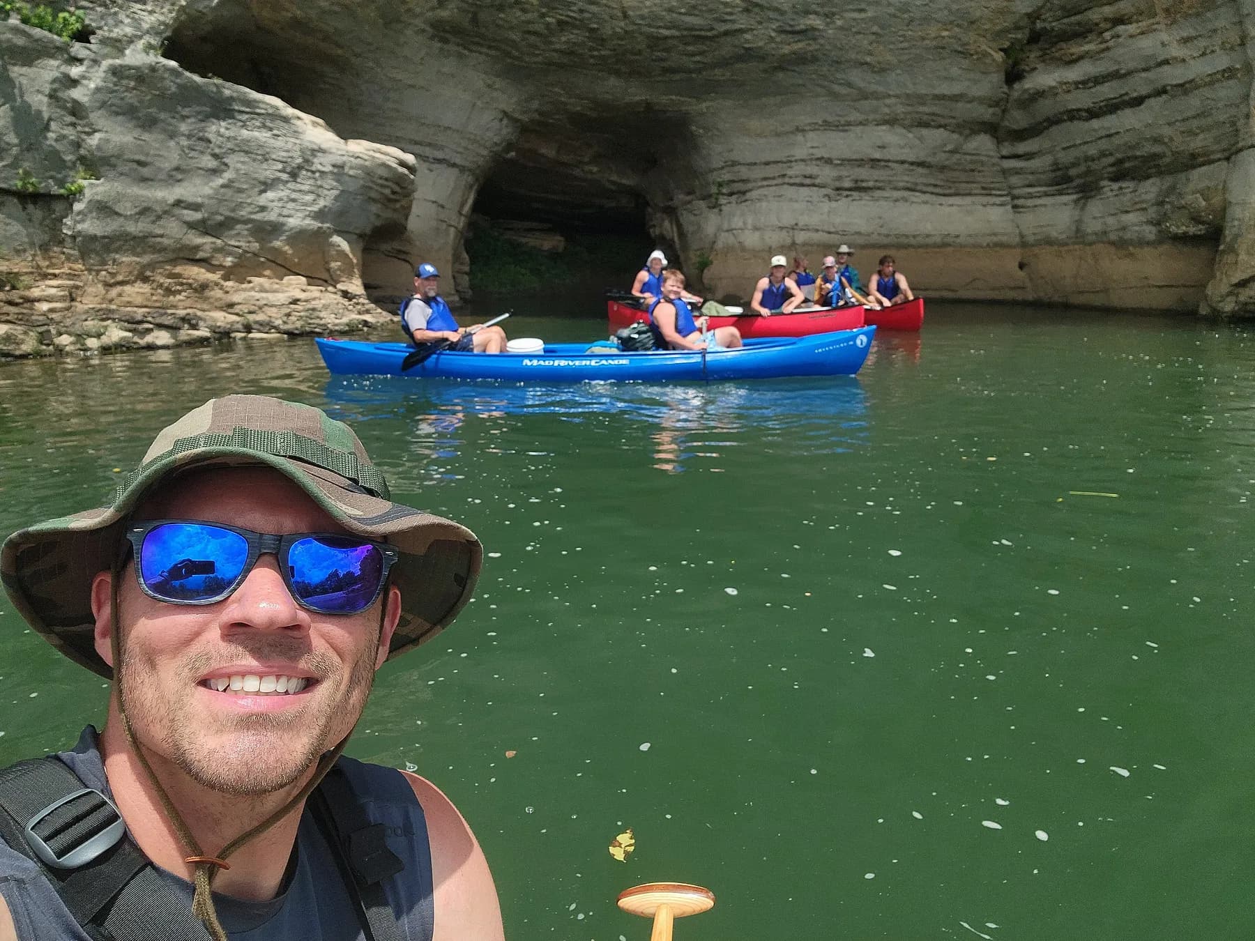 A Compass Outdoors leader on the river with canoes behind him